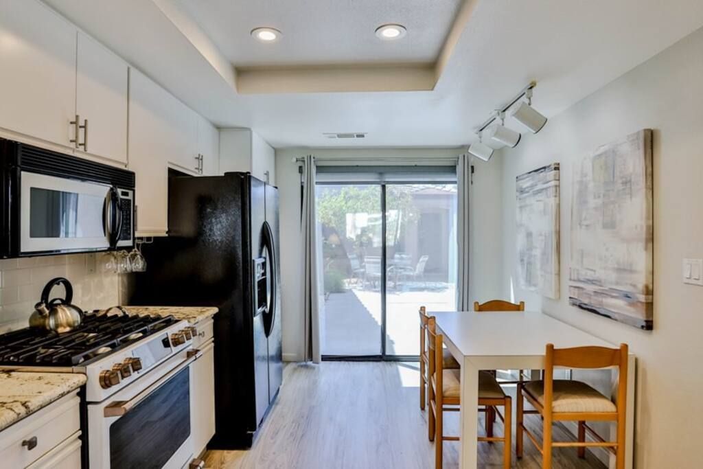 A kitchen with a table and chairs and a sliding glass door- California- Trip- Summer