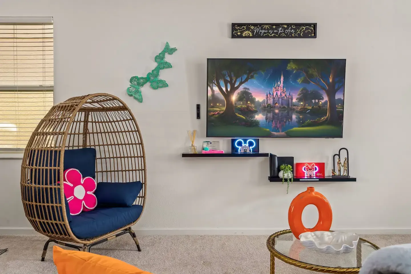 A living room with a wicker chair and a flat screen tv.