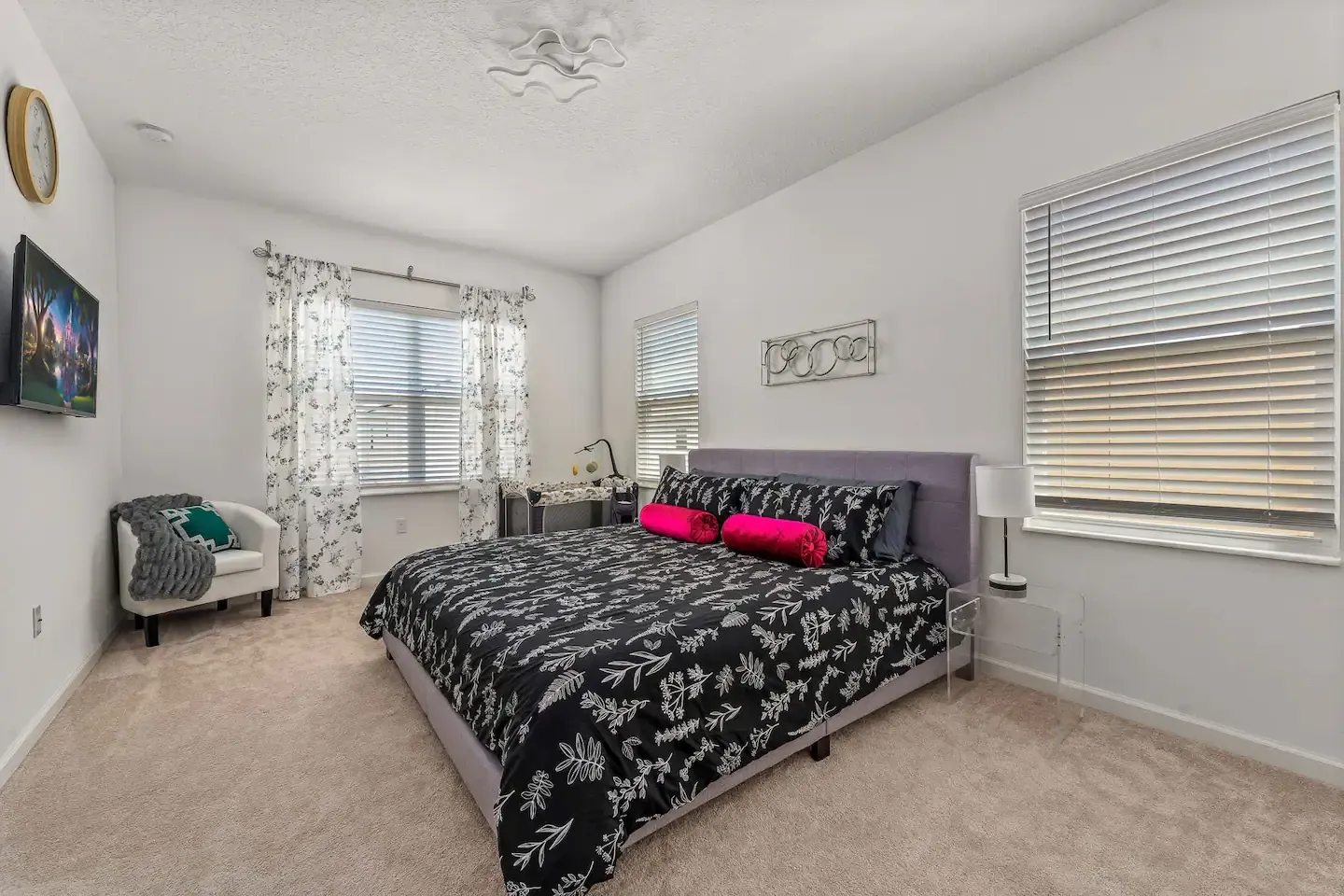A bedroom with a king size bed , chair , and television.