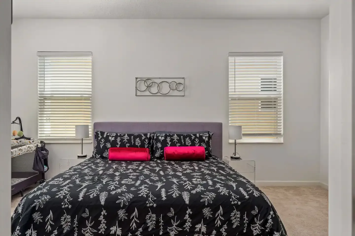 A bedroom with a king size bed and two windows.