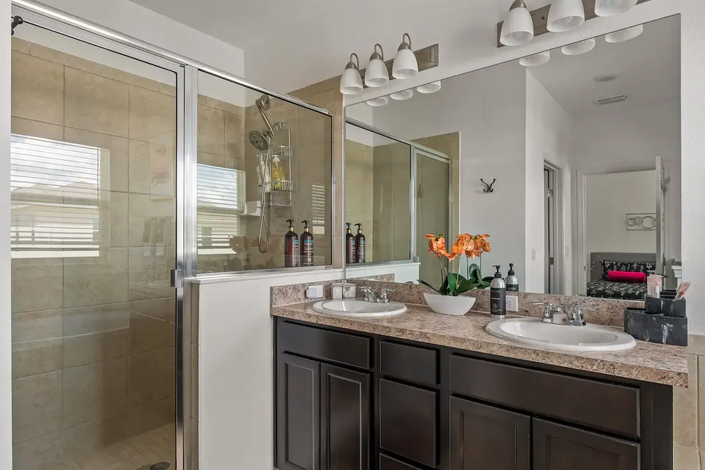 A bathroom with two sinks and a walk in shower.