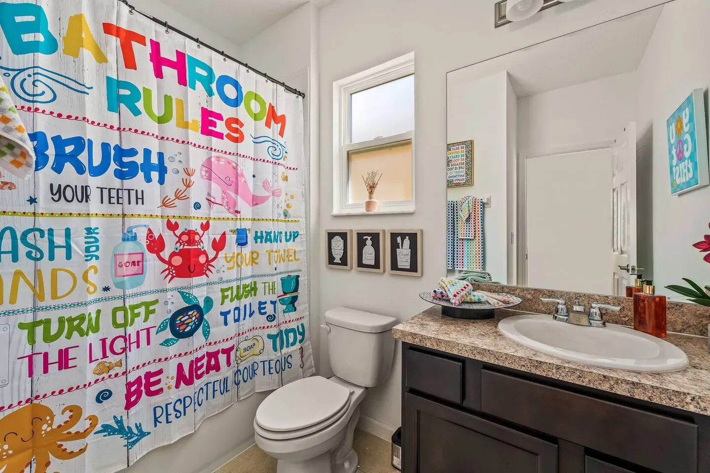 A bathroom with a toilet , sink , and shower curtain.
