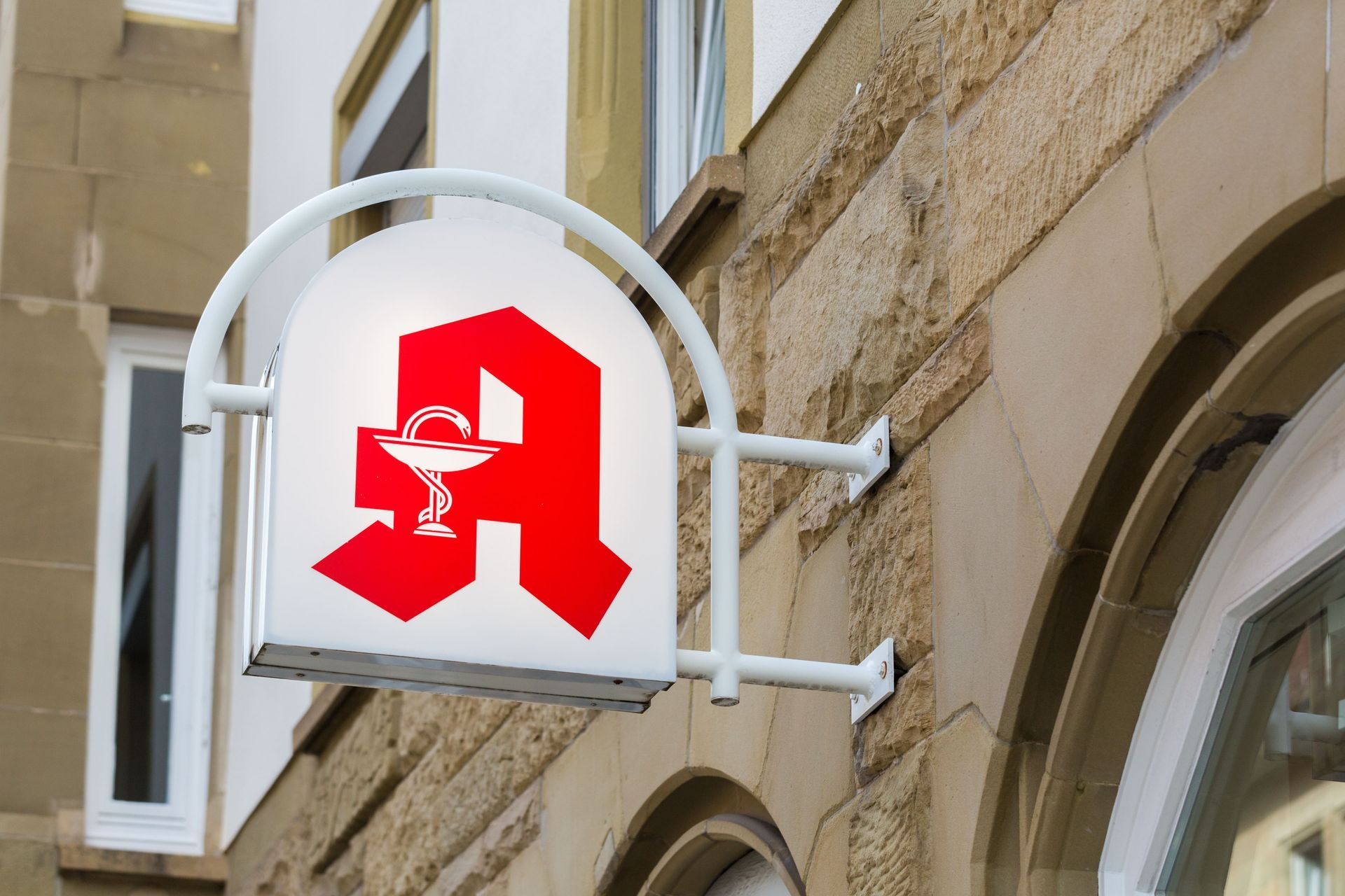 Apotheke kaufen: Ein Apothekenschild hängt an der Seite eines Gebäudes