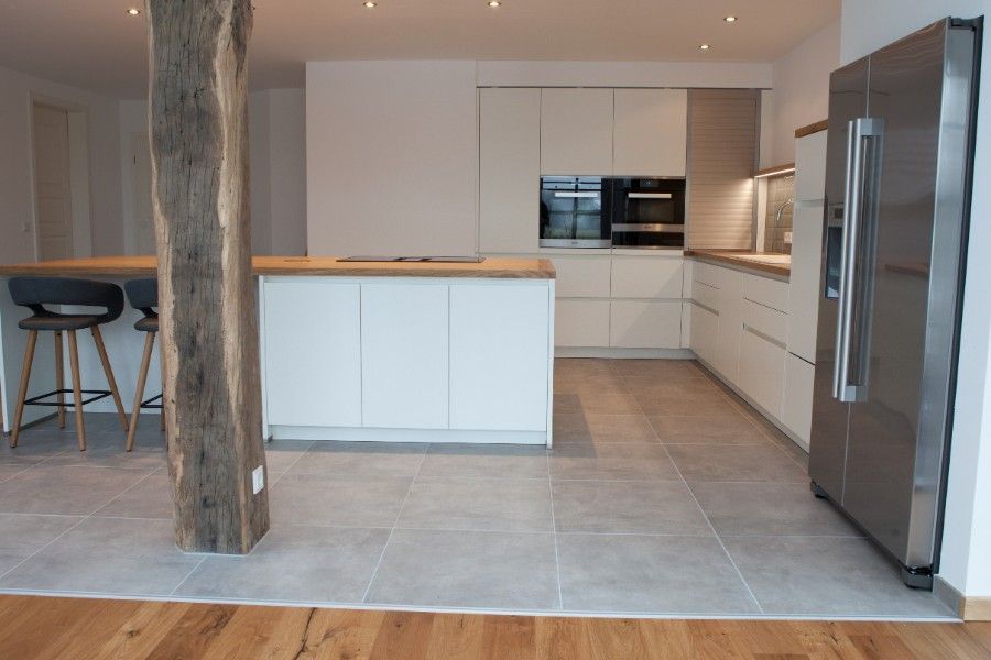 Holzwaschtisch mit schwarzer Oberseite und weißer Front mit zwei Schubladen, die dieselbe Breite wie der Schrank haben. Ein weißes rundes modernes Waschbecken mit verchromter Mischbatterie steht oben rechts auf dem Schrank.