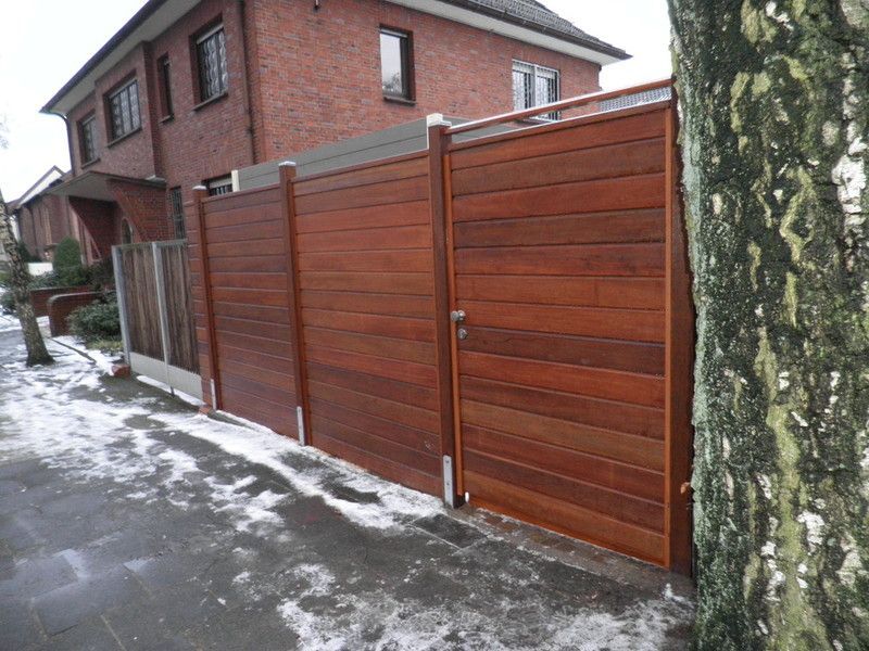 Holzwaschtisch mit schwarzer Oberseite und weißer Front mit zwei Schubladen, die dieselbe Breite wie der Schrank haben. Ein weißes rundes modernes Waschbecken mit verchromter Mischbatterie steht oben rechts auf dem Schrank.