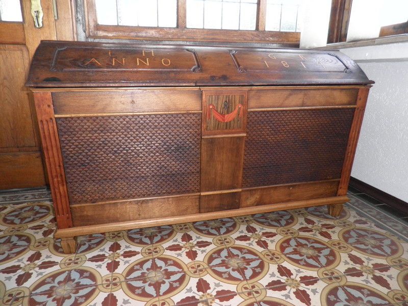 Holzwaschtisch mit schwarzer Oberseite und weißer Front mit zwei Schubladen, die dieselbe Breite wie der Schrank haben. Ein weißes rundes modernes Waschbecken mit verchromter Mischbatterie steht oben rechts auf dem Schrank.