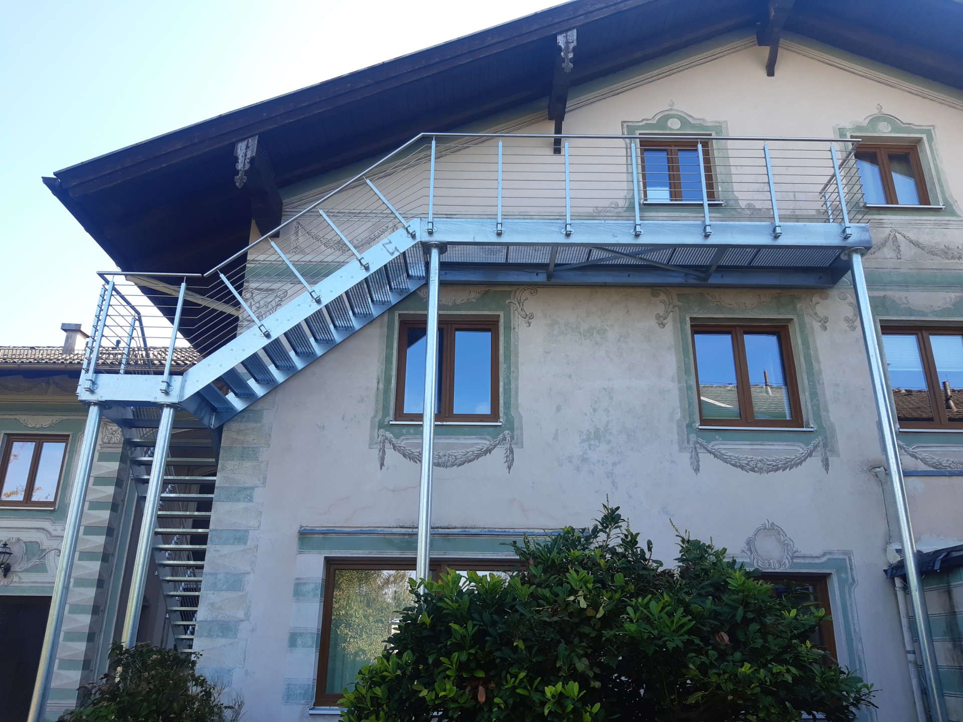 Außentreppen an einer Häuserwand mit Geländer aus Metall