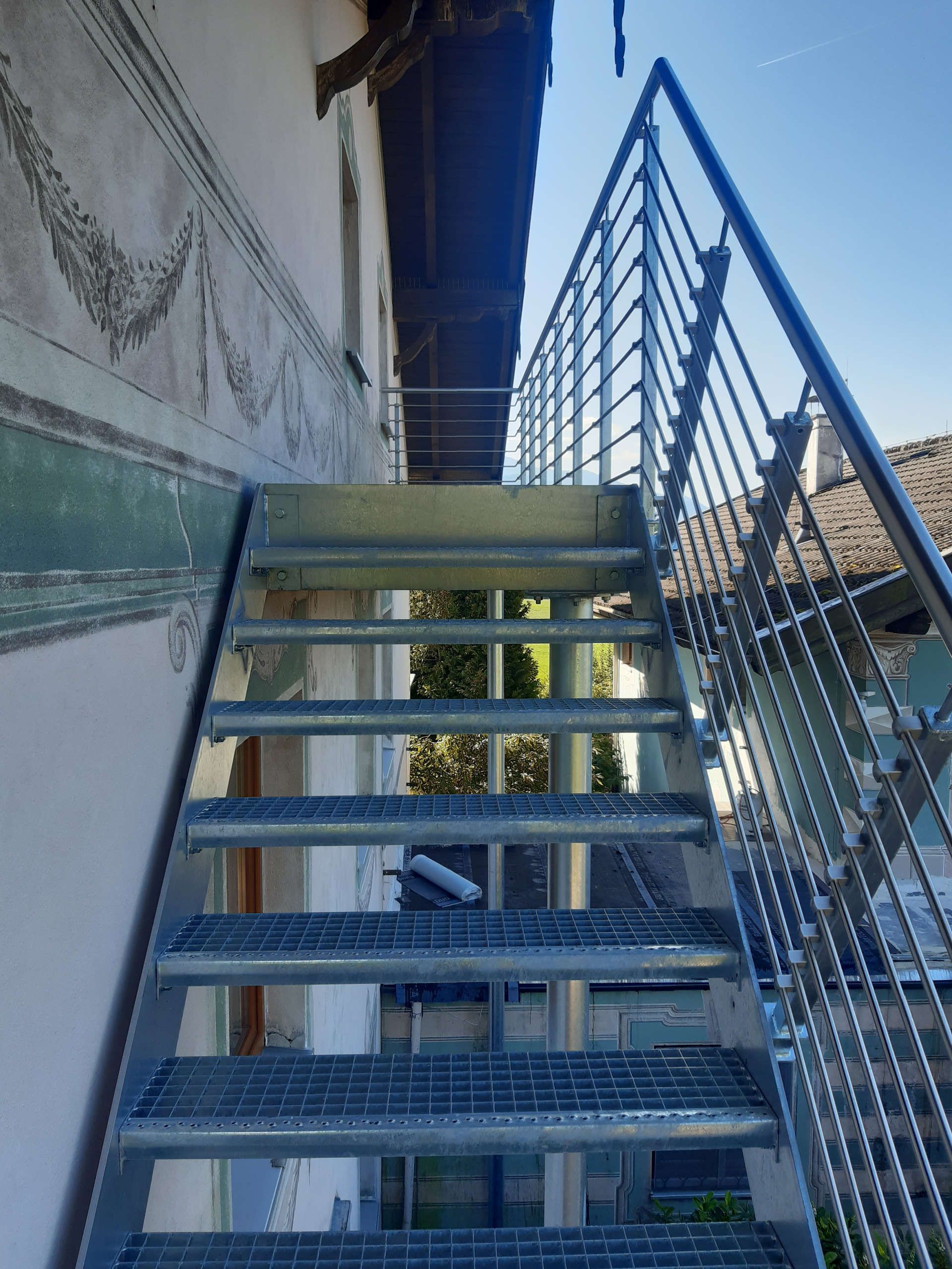 Außentreppen an einer Häuserwand mit Geländer aus Metall