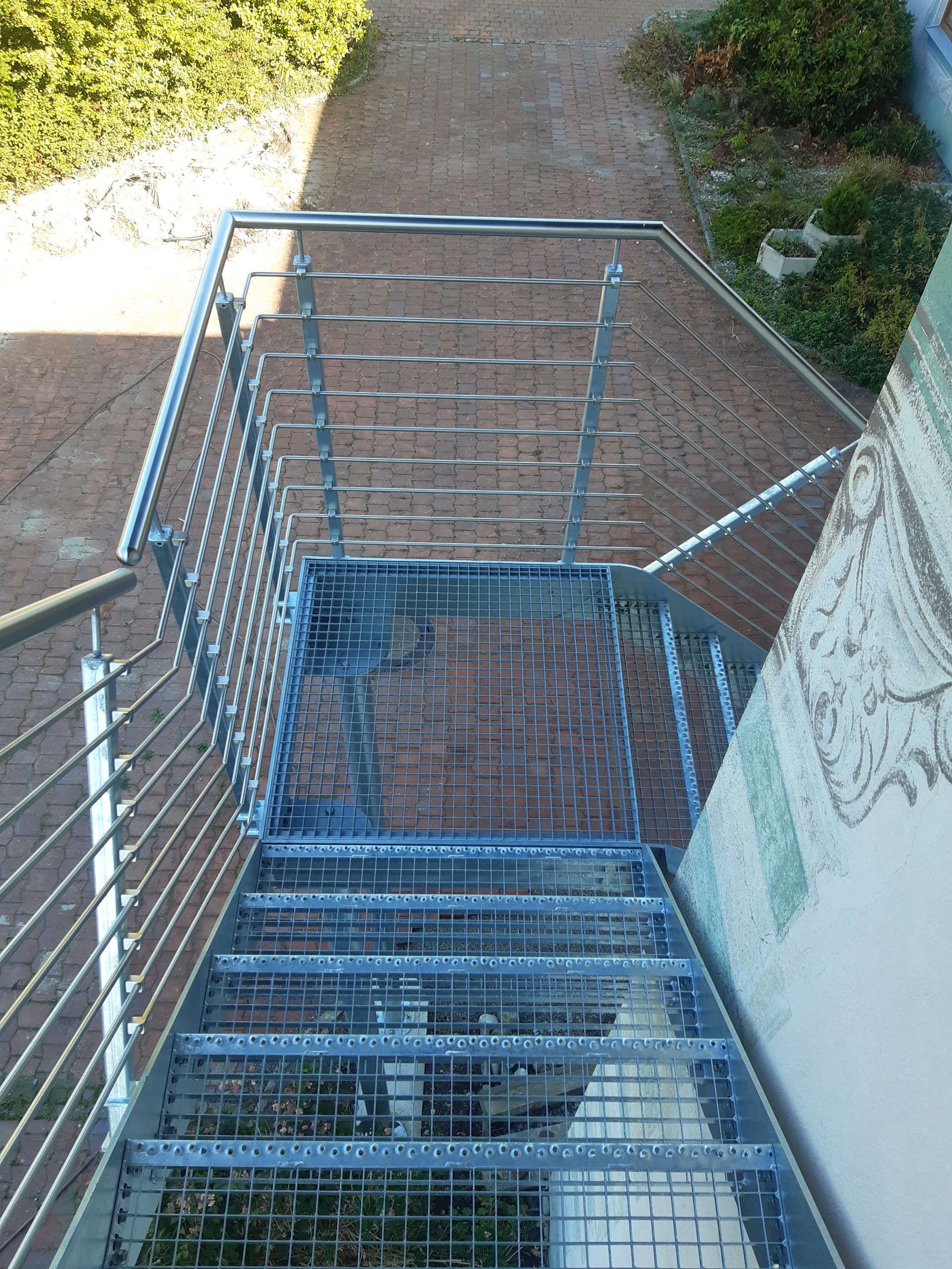 Außentreppen an einer Häuserwand mit Geländer aus Metall