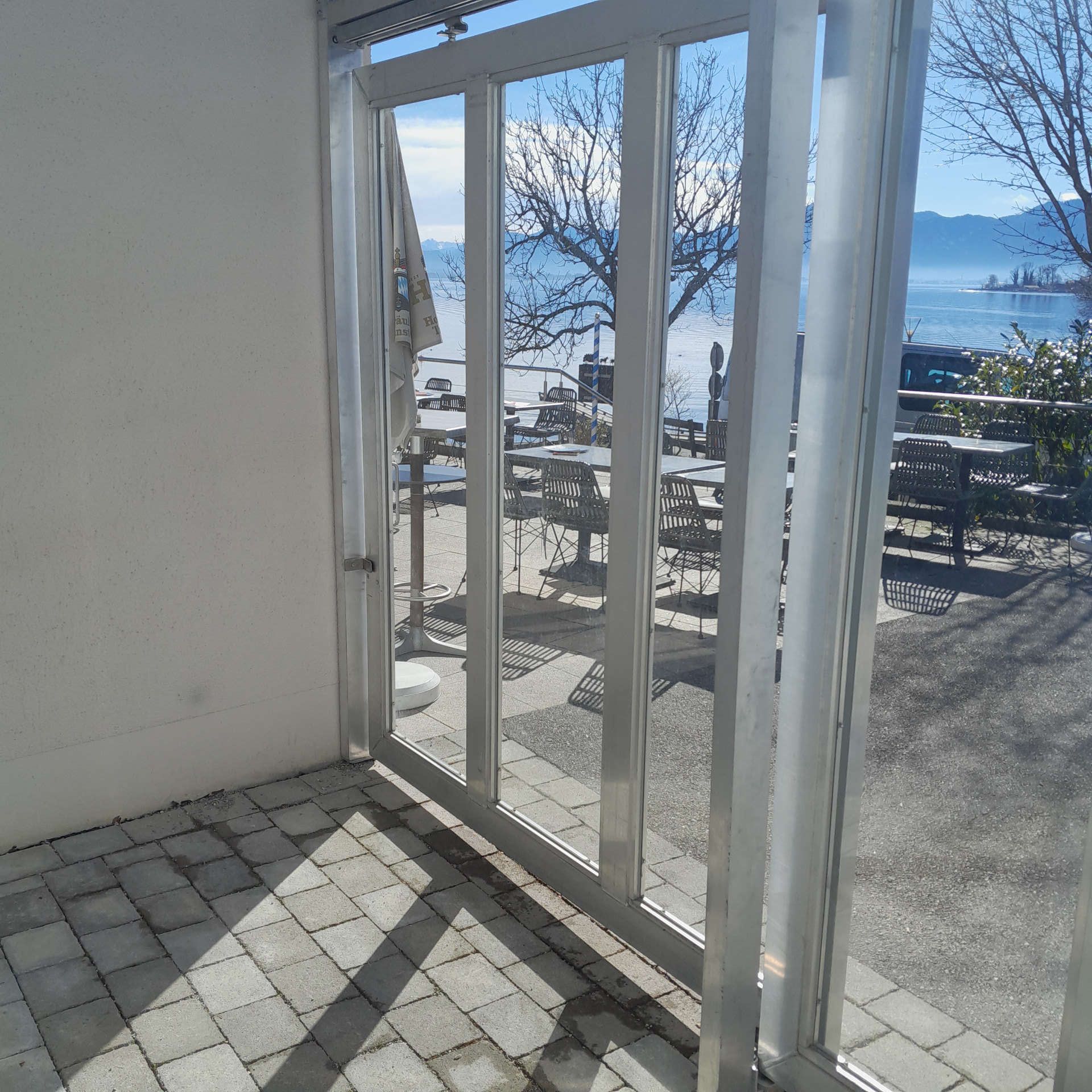 Vordachkonstruktion mit zwei Frontschiebetüren aus Aluminium mit Festverglasung von innen betrachtet