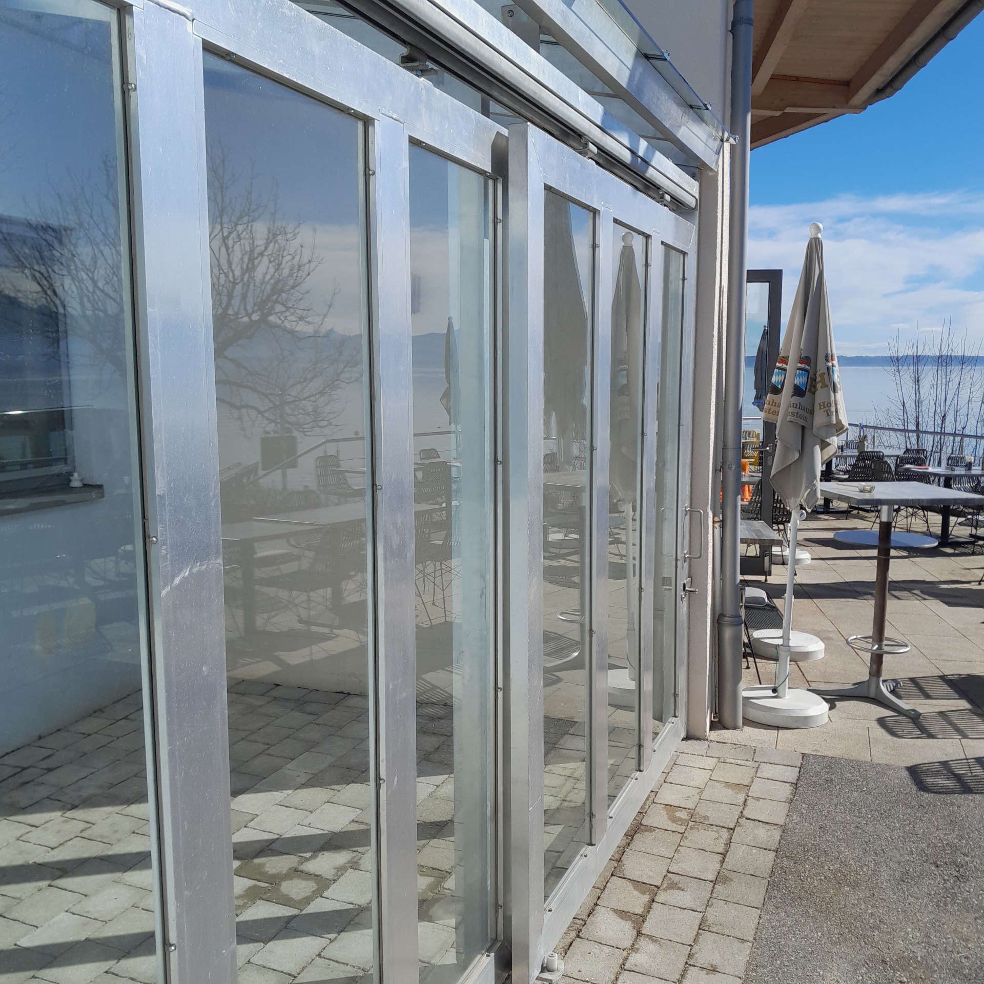 Vordachkonstruktion mit zwei Frontschiebetüren aus Aluminium mit Festverglasung und geschlossenen Türen von der Seite