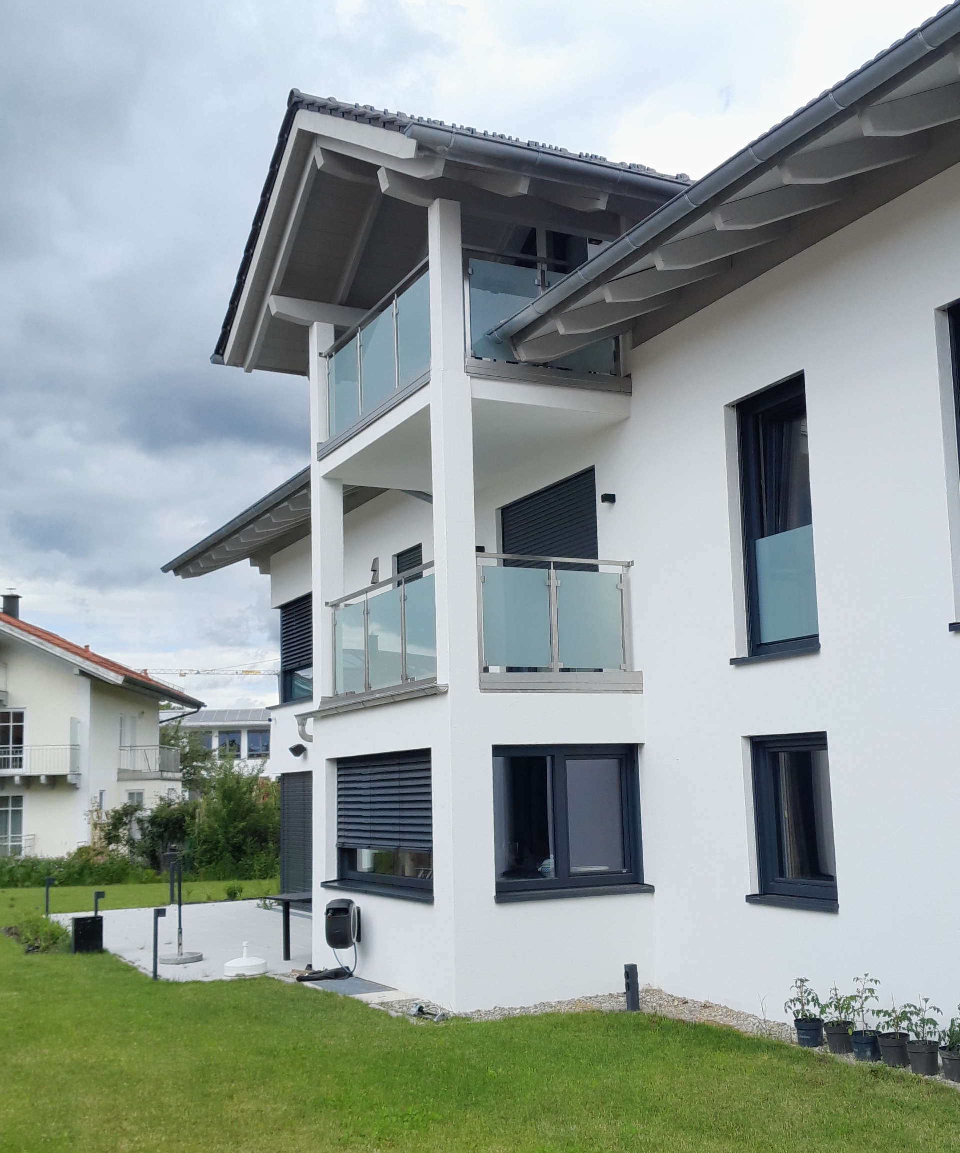 Ein weißes Haus mit 2 Balkonen übereinander (Seitenansicht)