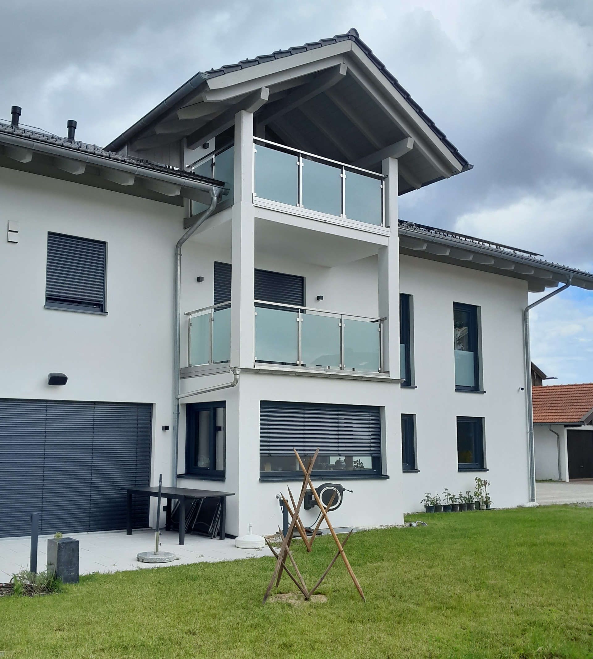 Ein weißes Haus mit 2 Balkonen übereinander (Schrägansicht)