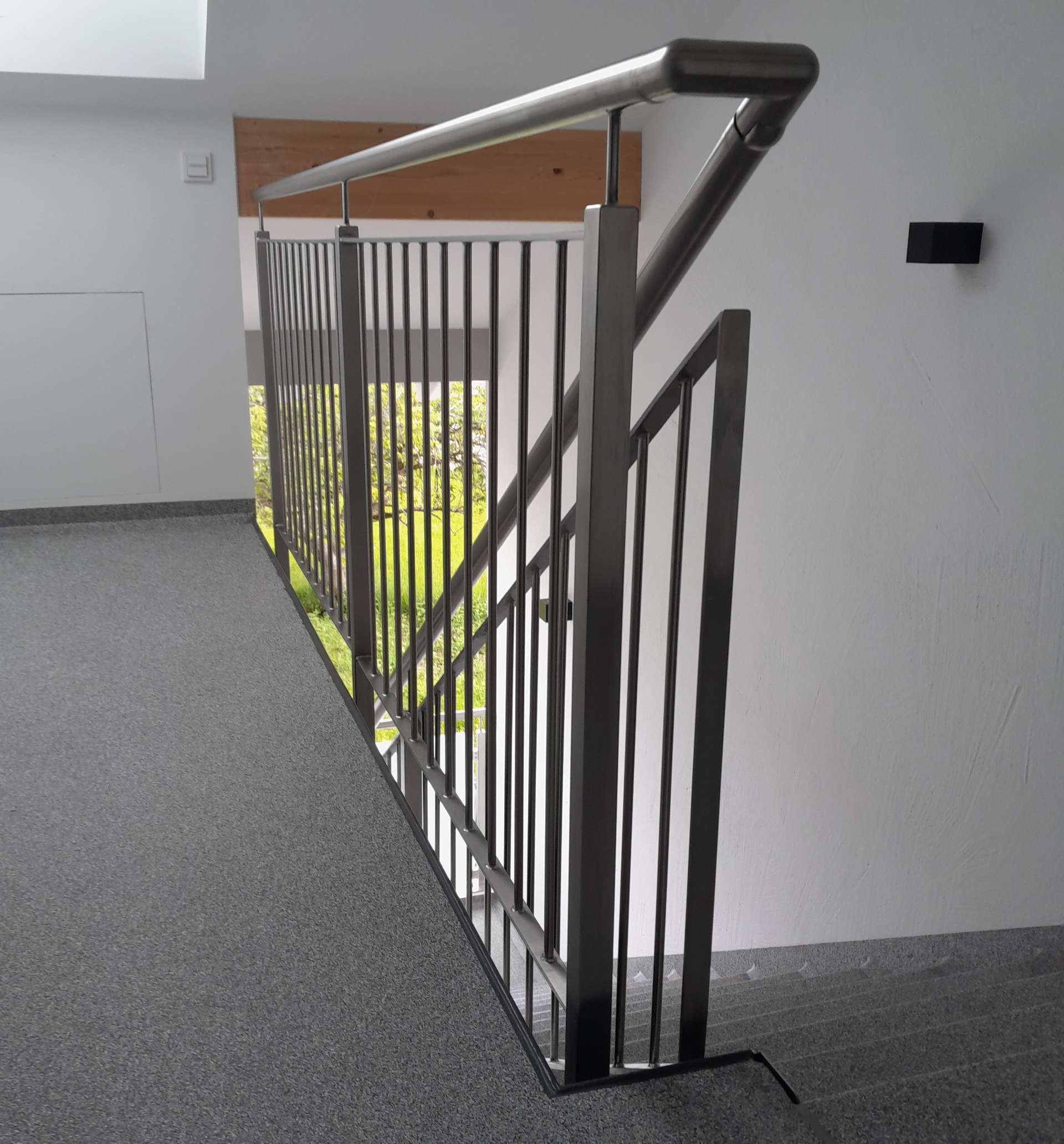 Eine Treppe mit Metallgeländer und Teppichboden.