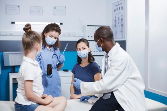 Un médico está administrando una vacuna a un niño en una habitación de hospital.