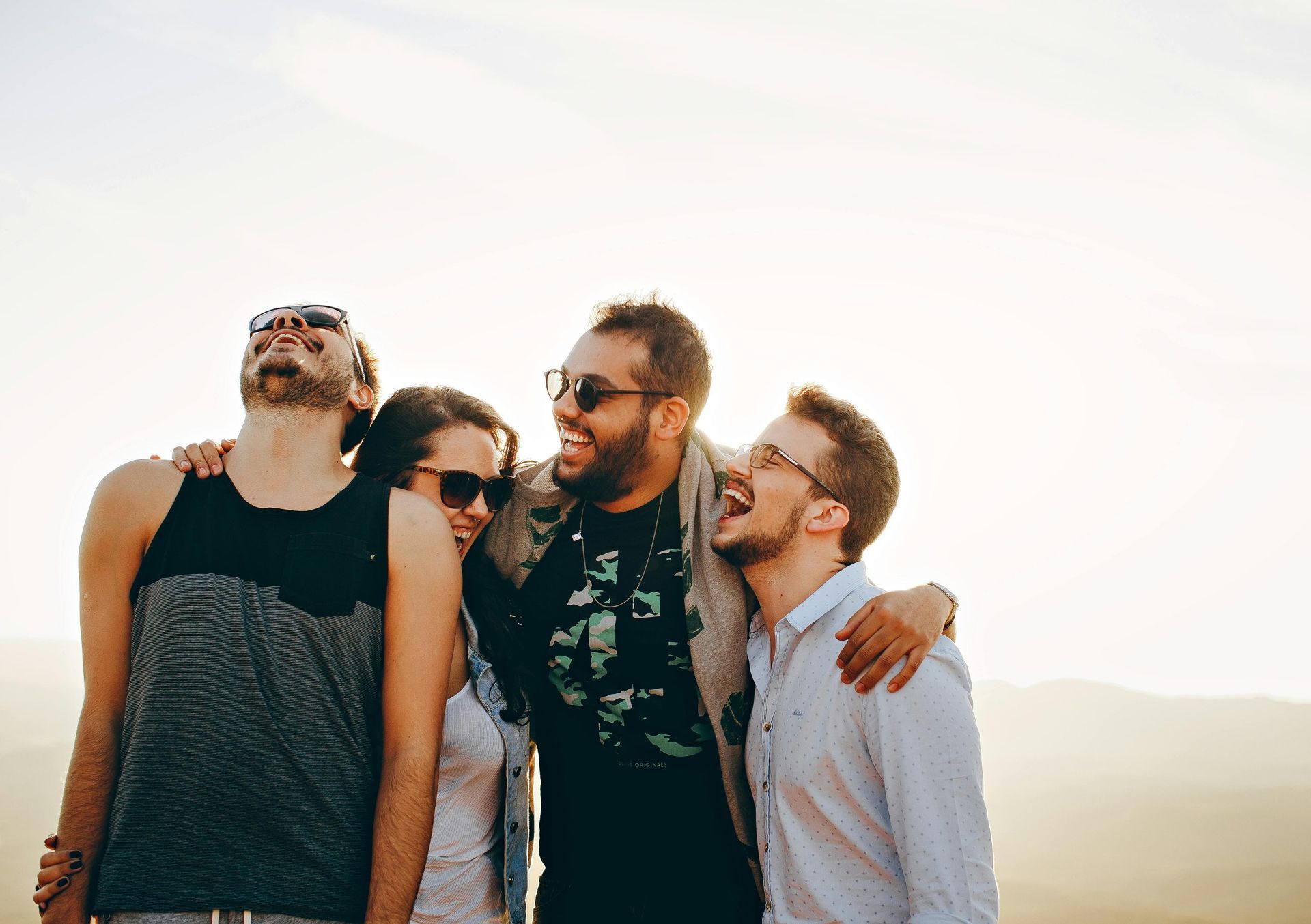 Un grupo de personas están de pie una al lado de la otra y ríen.