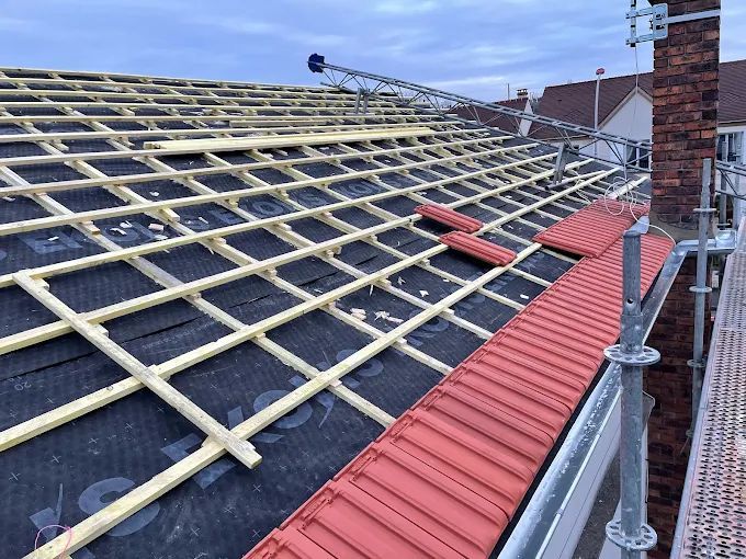 Quelques tuiles sur un toit en construction.