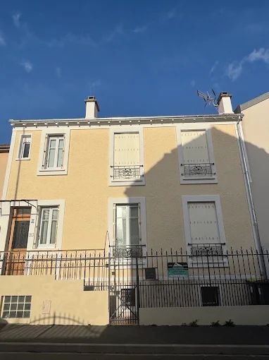 La façade d'un bâtiment avec des volets blancs.
