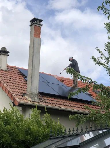 Un homme nettoie des panneaux solaires.