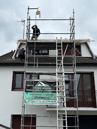 Un échafaudage devant un mur blanc.