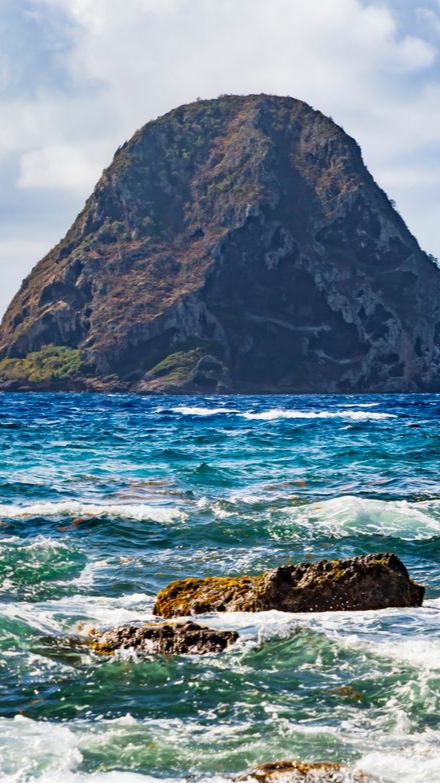 Île escarpée émergeant d'un océan.