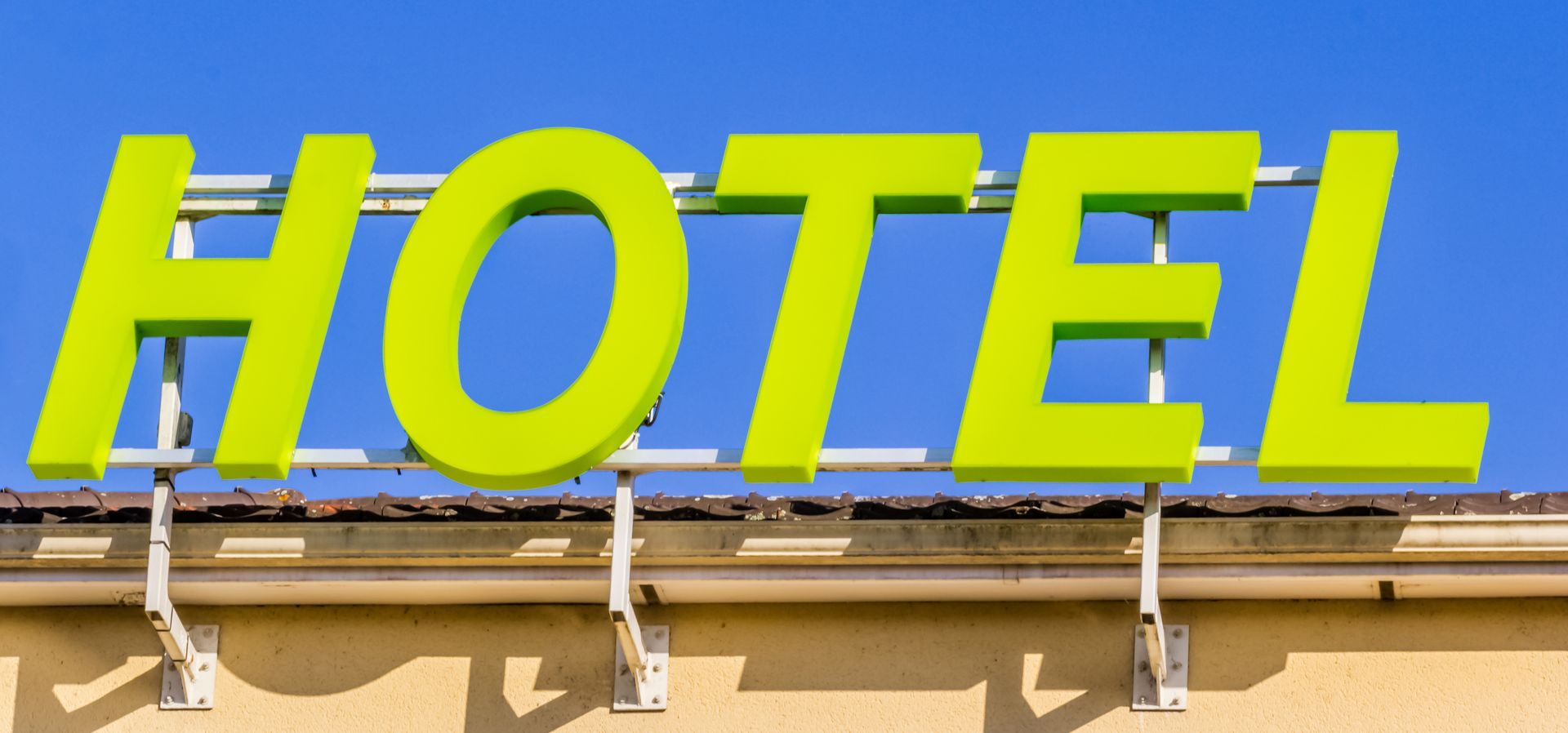 Enseigne verte sur fond apposée sur un bâtiment.