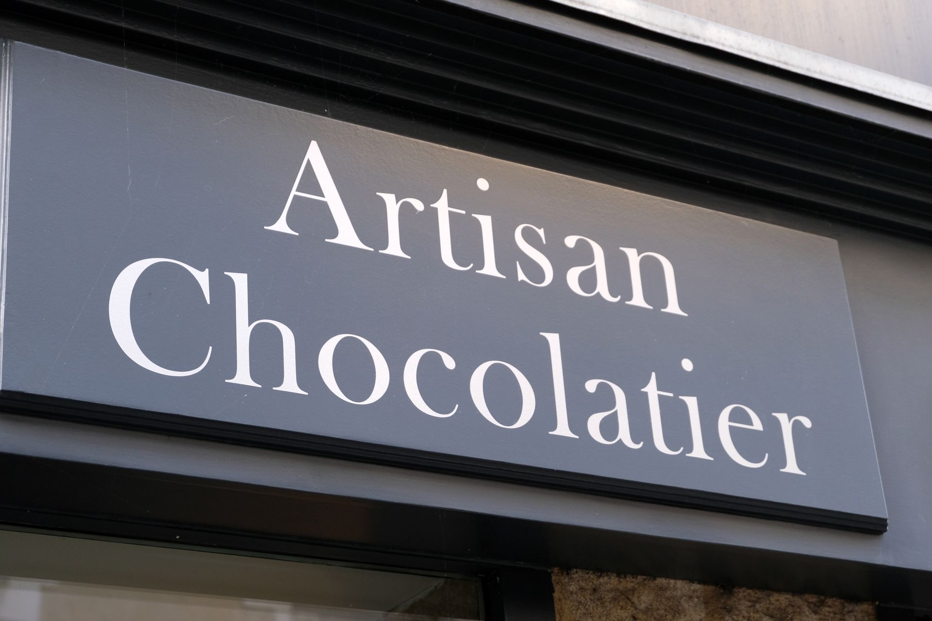 Panneau gris avec une inscription Artisan Chocolatier.