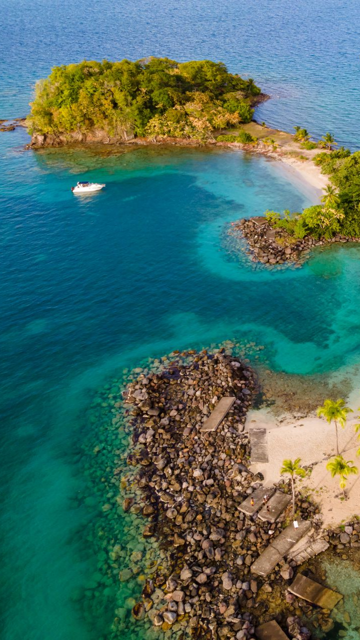 Vue aérienne d'une île avec une plage de sable blanc et un bateau.