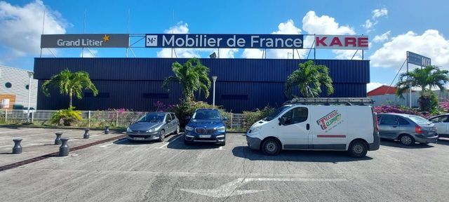 Façade d'un magasin de meubles donnant sur un stationnement.