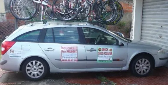 Voiture argentée avec des vélos sur le toit.