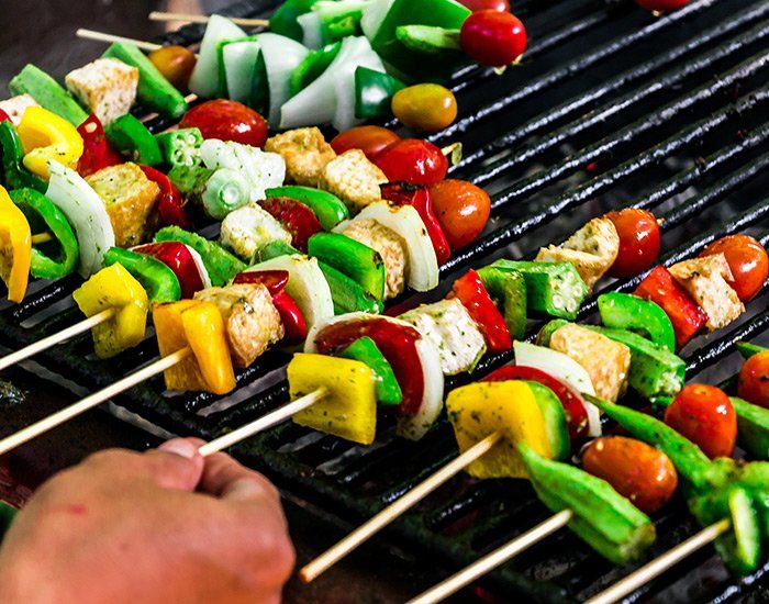 Plusieurs brochettes de légumes sur un barbecue