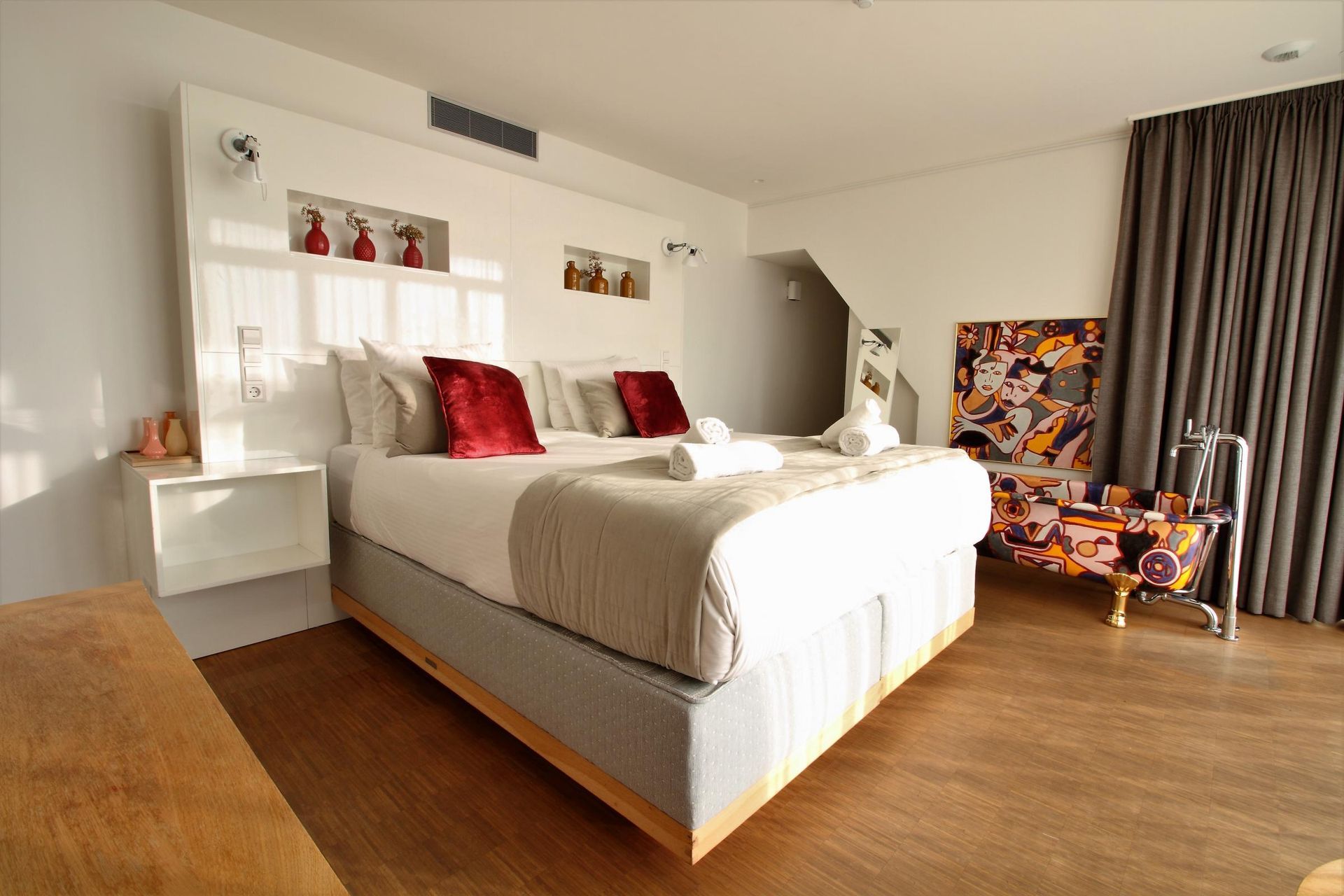 A hotel room with a large bed and a chair