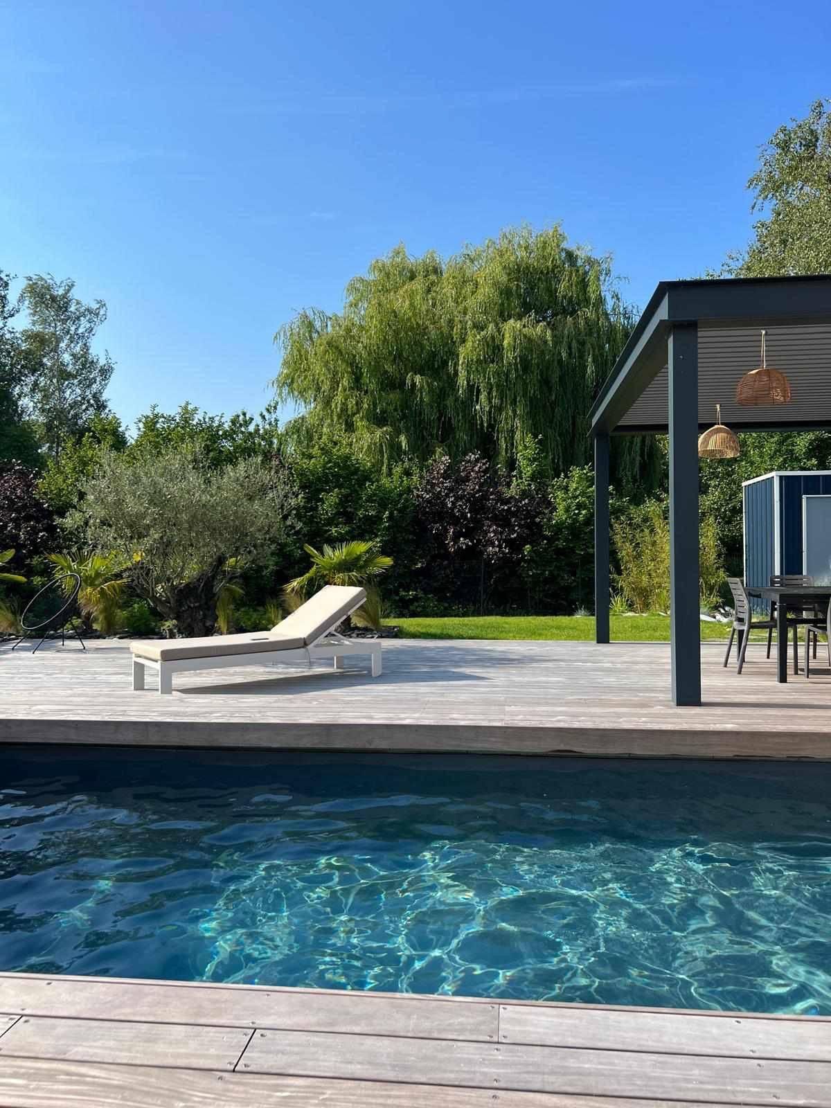 Plante exotique sortant de terre au milieu d'une piscine en bois