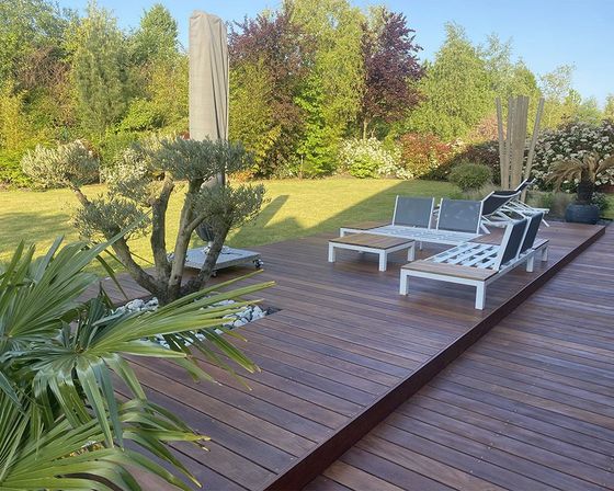 Terrasse en bois sur laquelle est disposé un salon de jardin