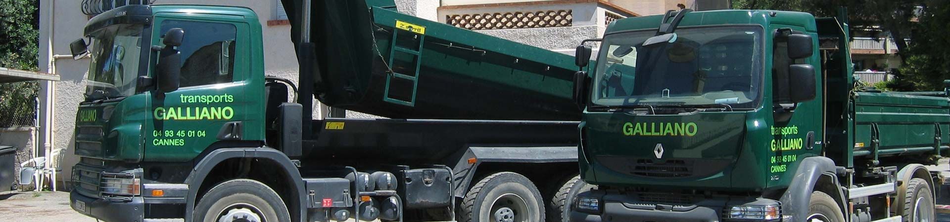 Deux camions Galliand verts, benne basculante levée, sont garés côte à côte. La scène se déroule en extérieur, probablement en journée.