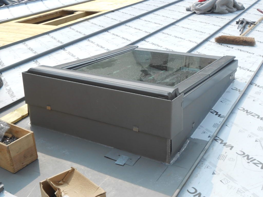 Puits de lumière ou trappe de toit rectangulaire gris en cours de construction sur une toiture à membrane blanche