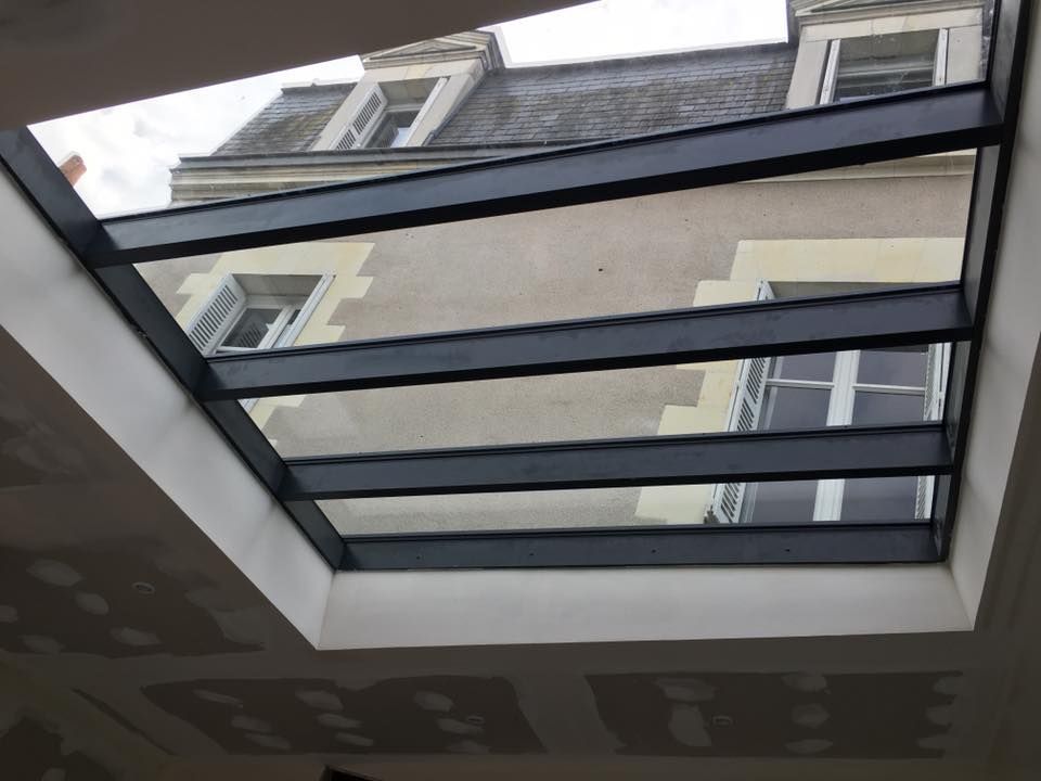 En regardant à travers une verrière la façade d'un bâtiment avec des fenêtres au-dessus.