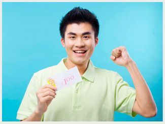 Un joven sostiene un trozo de papel con el número 100.