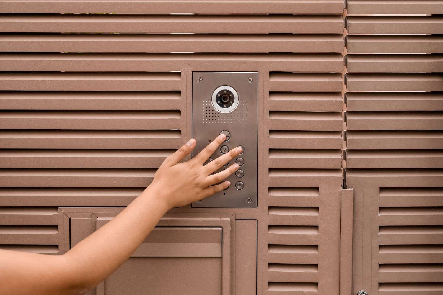 Persona usando videoportero en una comunidad de vecinos.