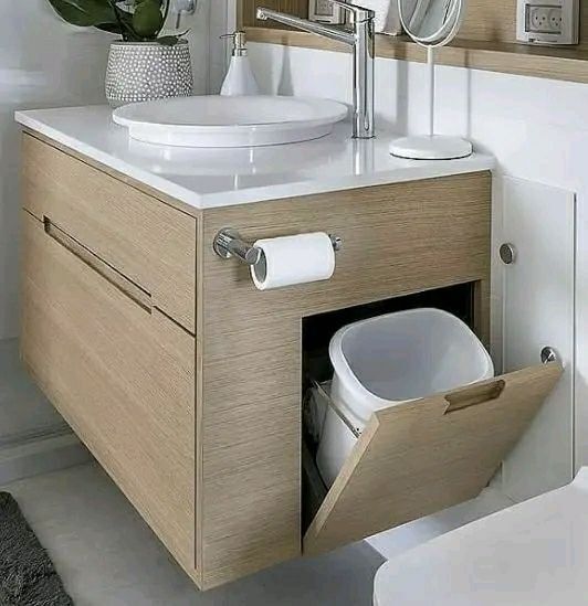 Un baño con lavabo, inodoro, espejo y papelera.