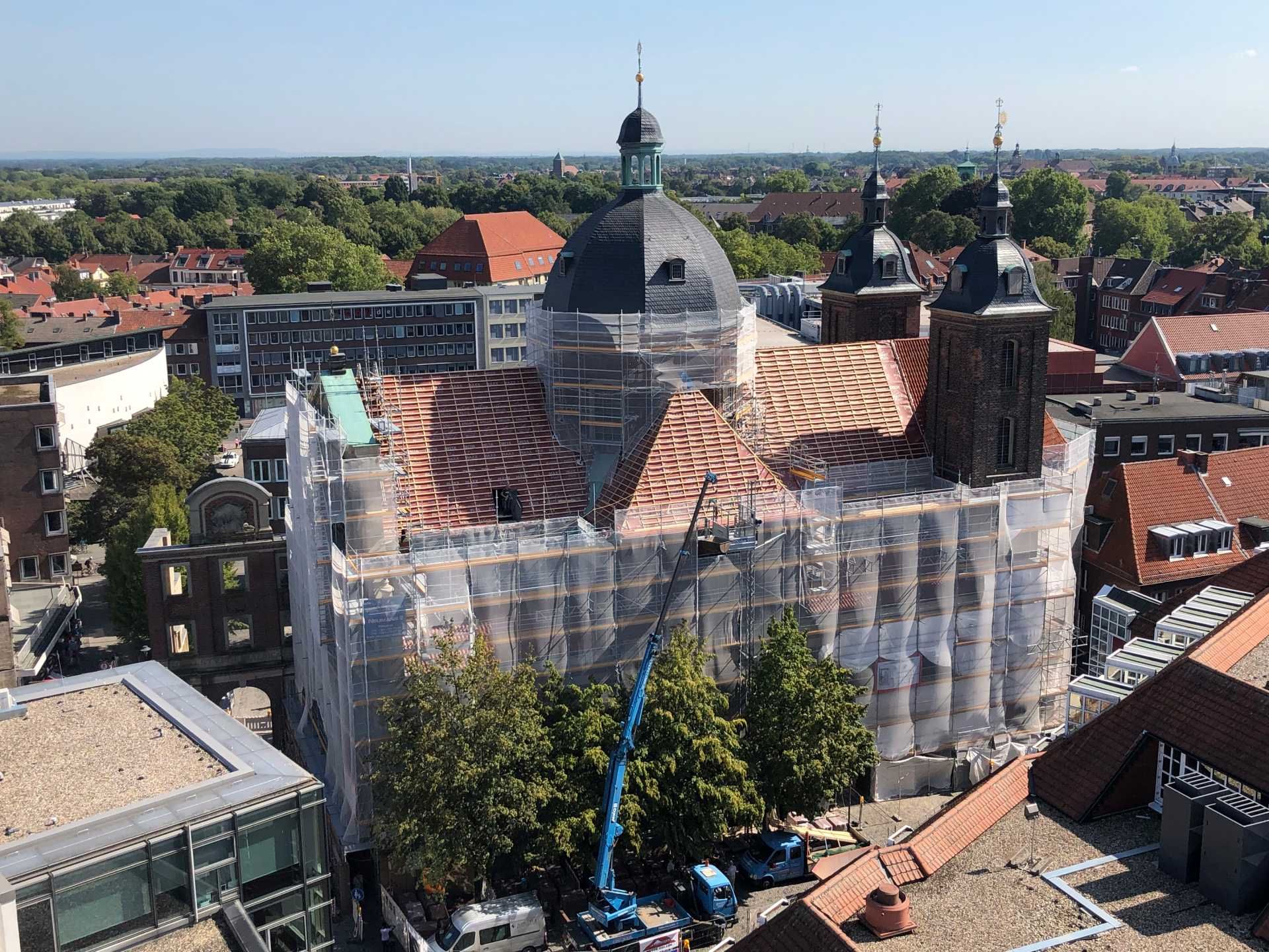 Eine Luftaufnahme eines großen, mit einem Gerüst bedeckten Gebäudes.