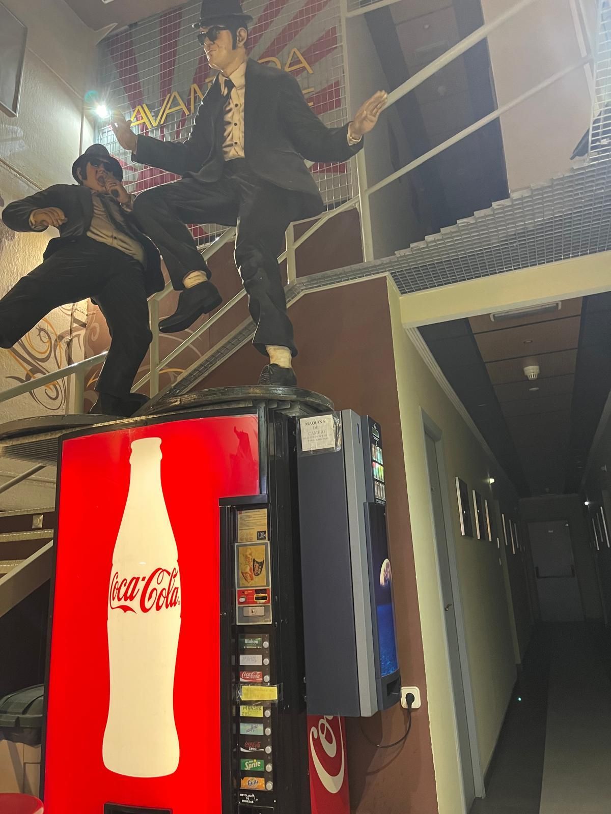 Estatuas de los Blues Brothers encima de una máquina expendedora de Coca-Cola, en el interior.