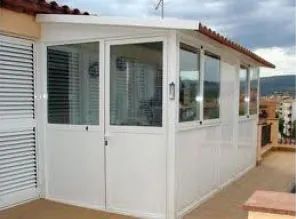 Un edificio blanco con muchas ventanas y puertas en un balcón.