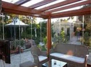 Una sala de estar con un sofá, sillas y una mesa de cristal.