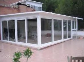 Una casa blanca con muchas ventanas y un patio.