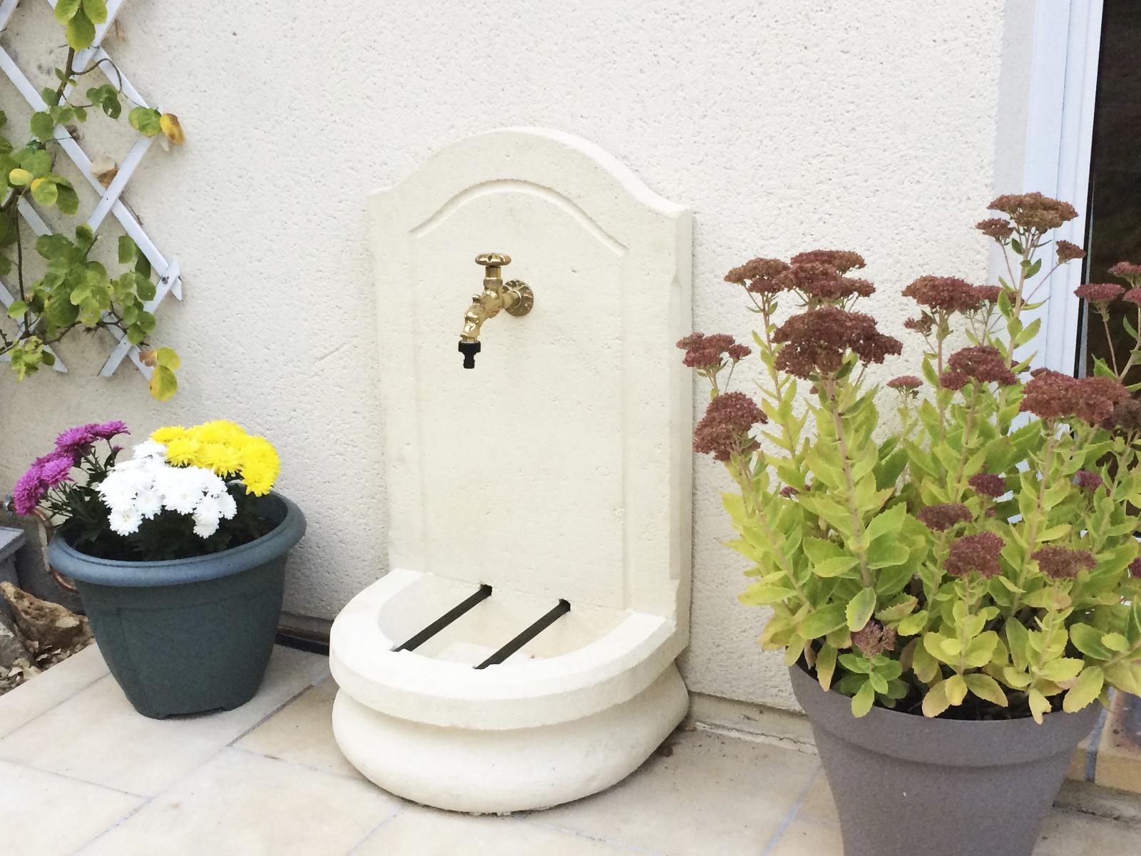 robinet extérieur de jardin entouré de plantes