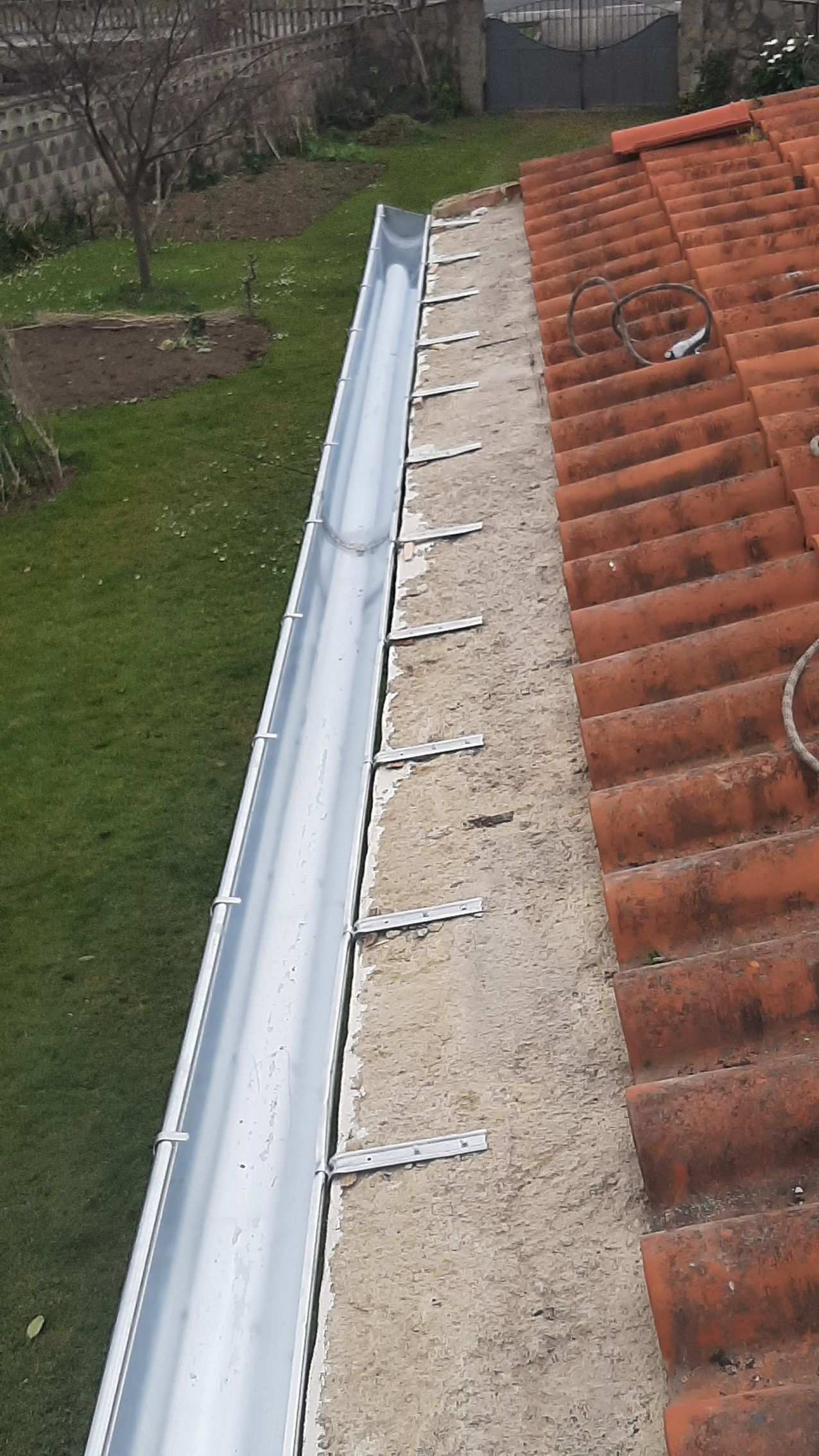 Se está instalando una canaleta en el lateral de un tejado.