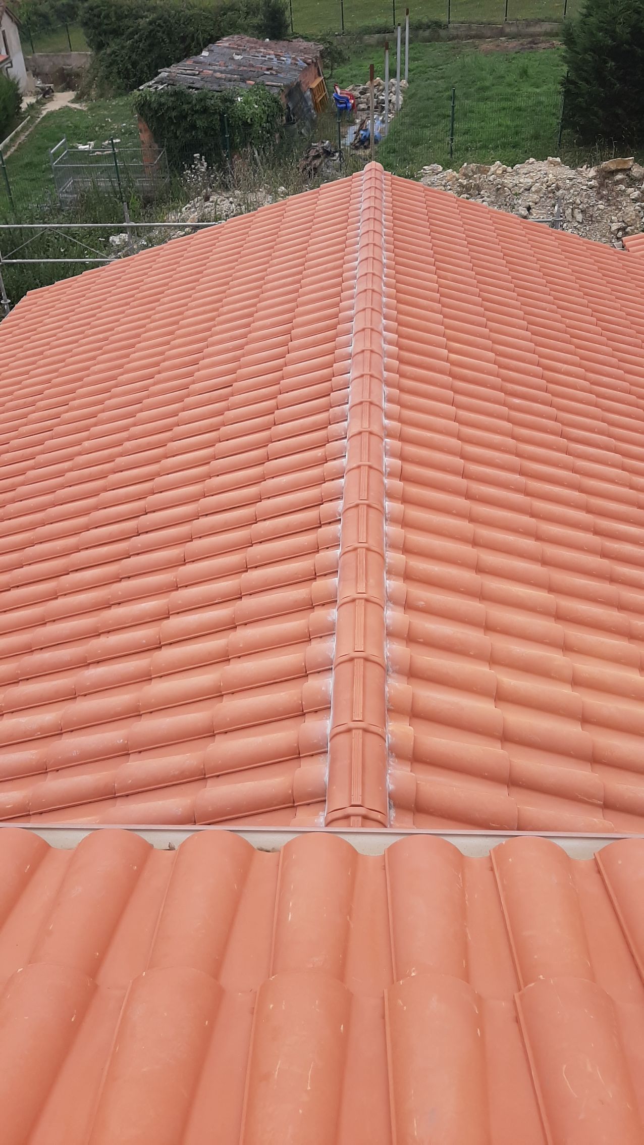 El techo de una casa está cubierto de tejas rojas.