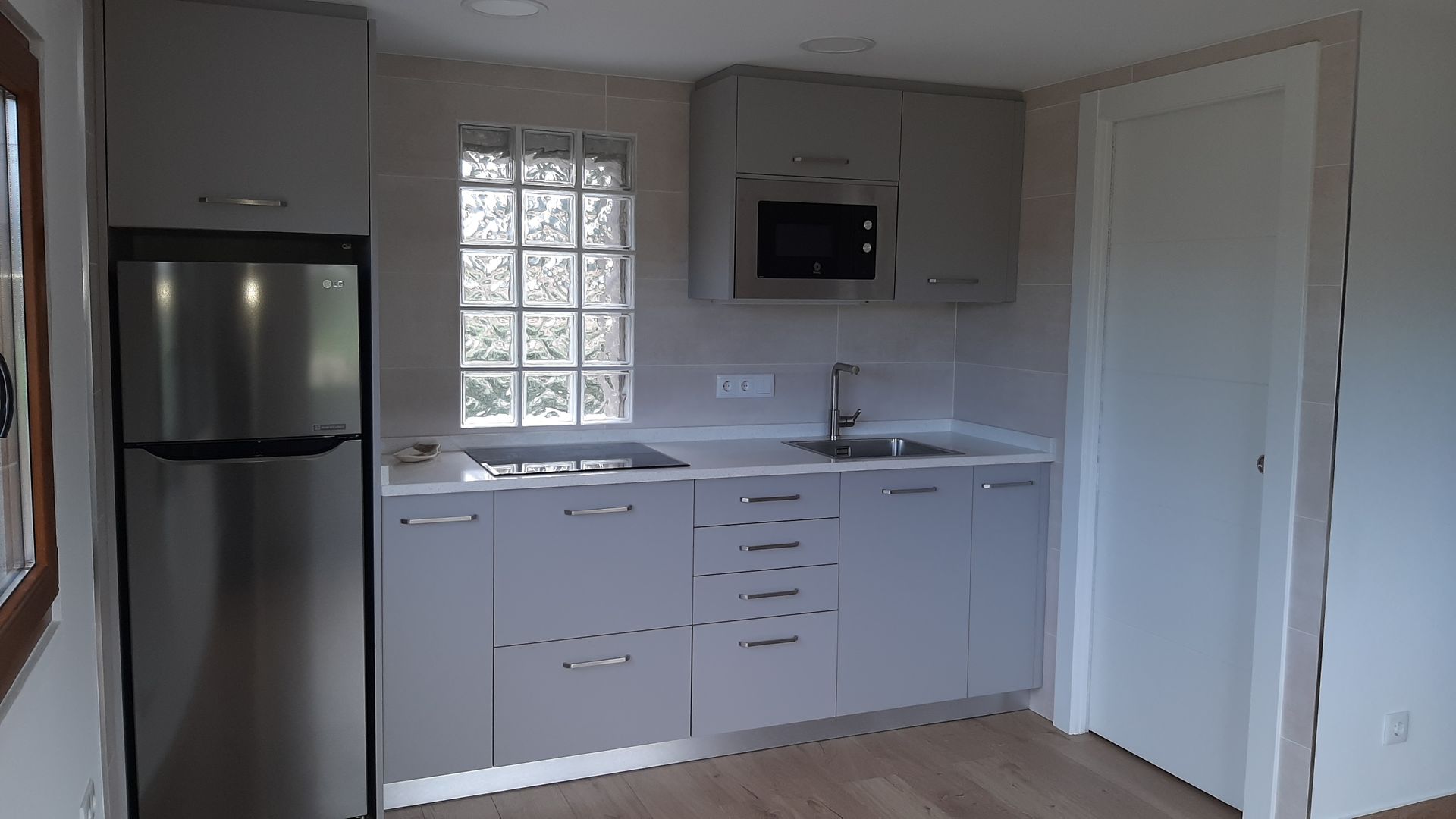 Una cocina con electrodomésticos de acero inoxidable y gabinetes grises.