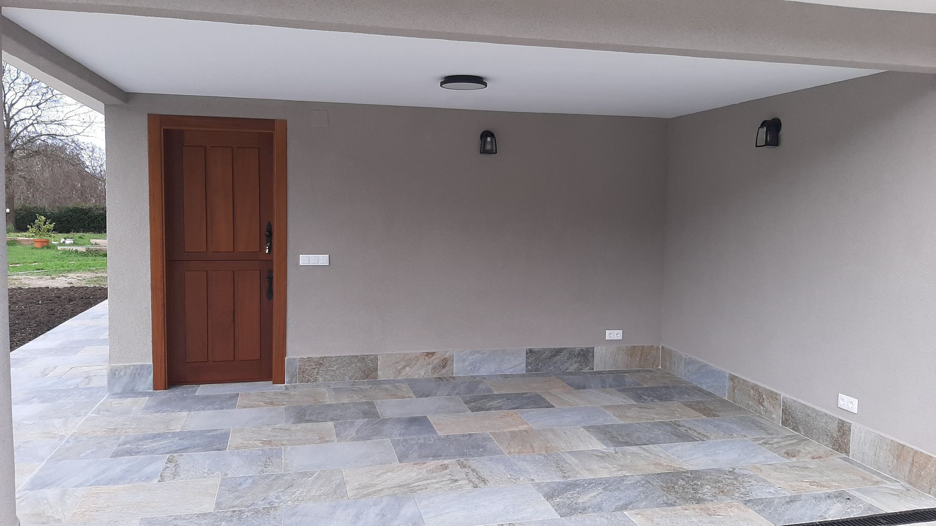 Un garaje con puerta de madera y suelo de baldosas.